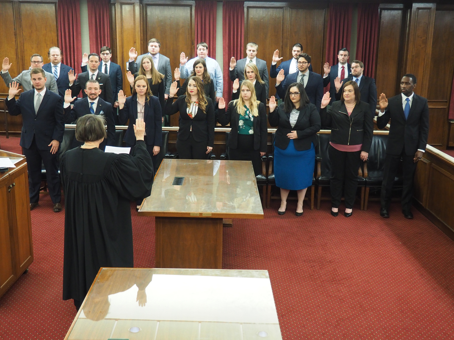 Group of students raising their right hands to be sworn in as Washburn Law Clinic interns by Justice Luckert.