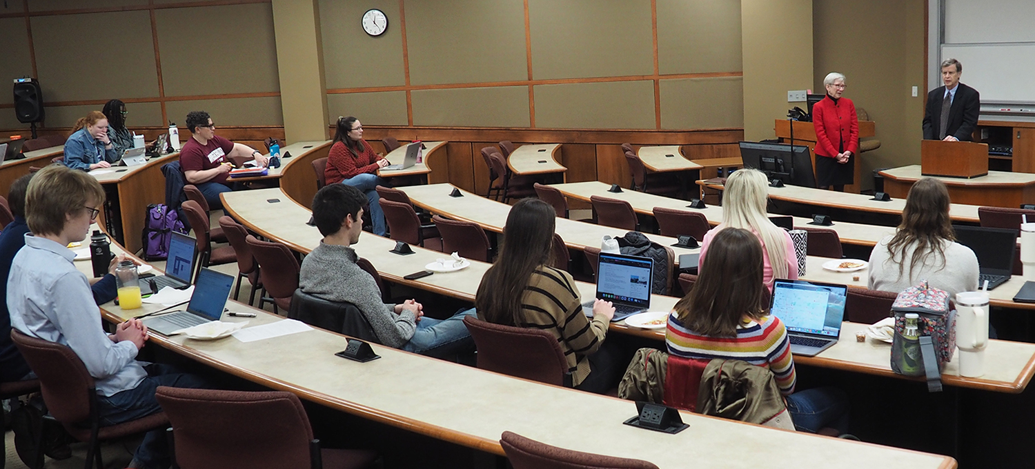 Photo: Dan and Helen Crow speaking to lecture hall of students