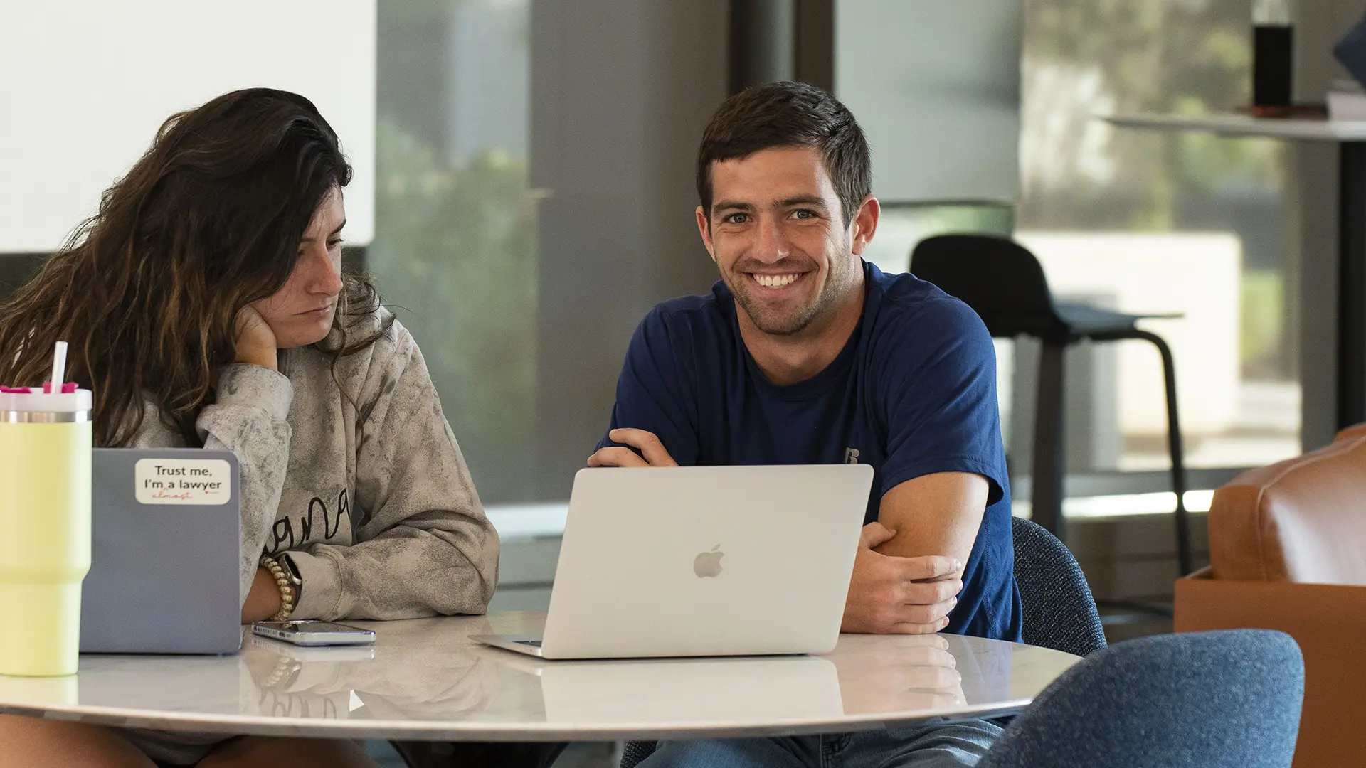 Two students sitting in front of a laptop computer