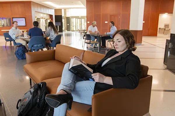student seated in chair in main lobby