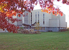 Photograph: West side of the law school building showing the statue of the eagle and autumn colors.